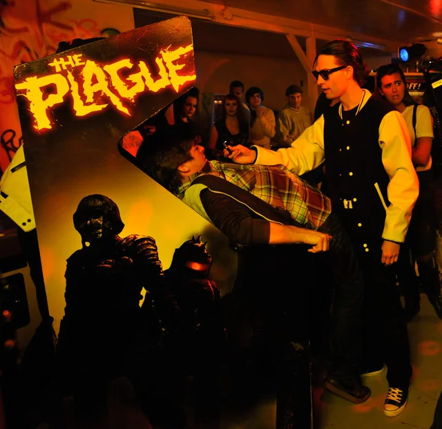 A still from the film Hobo With a Shotgun showing The Plague arcade game.