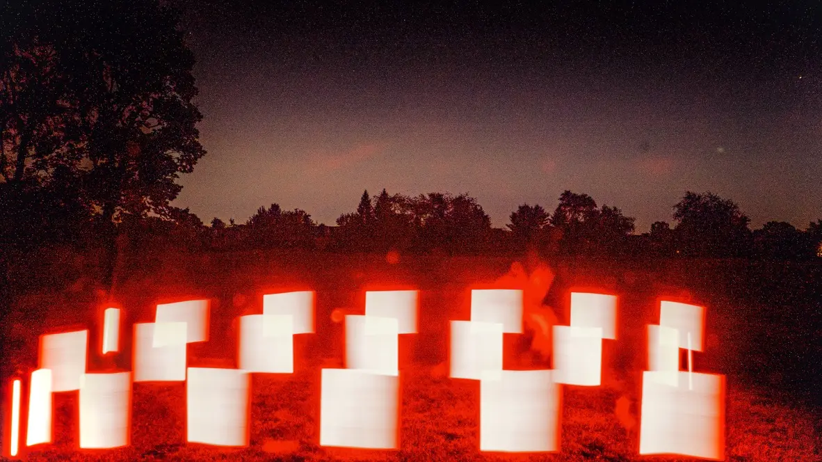 Experimental photograph with psychedelic, colorful shapes in a field outdoors at night.