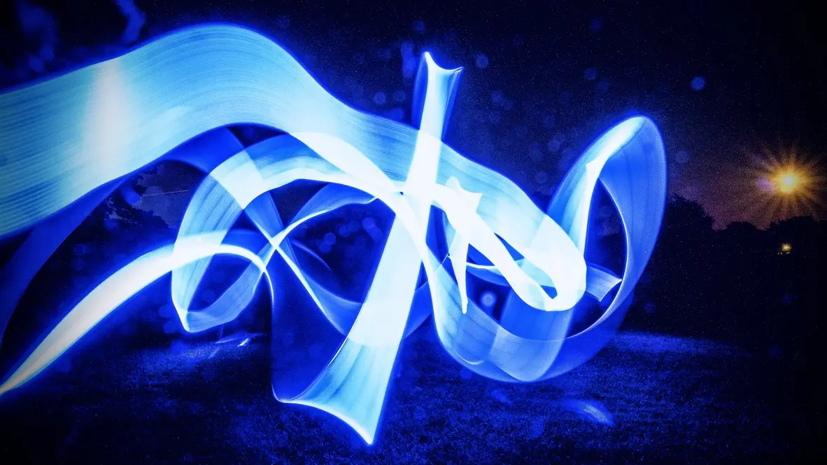 Experimental photograph with psychedelic, colorful shapes in a field outdoors at night.