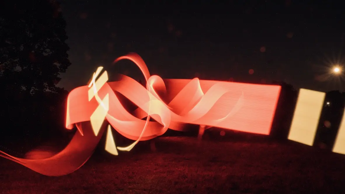 Experimental photograph with psychedelic, colorful shapes in a field outdoors at night.