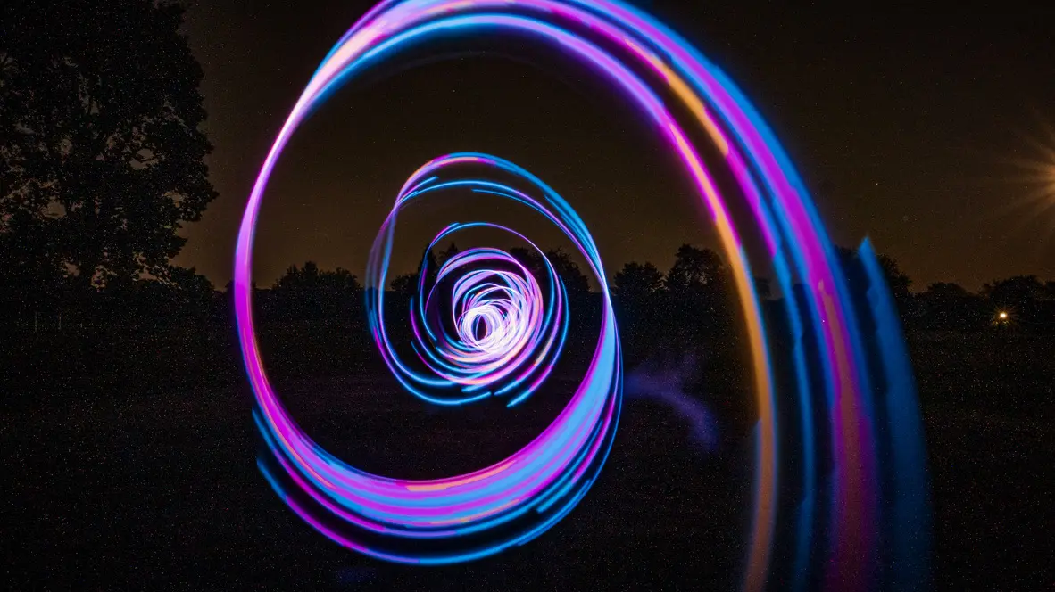 Experimental photograph with psychedelic, colorful shapes in a field outdoors at night.