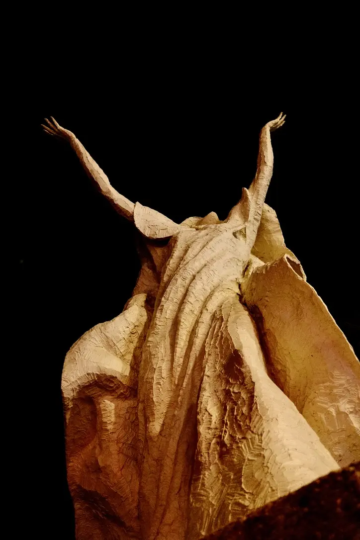 A statue raising its arms up into the night sky in Los Angeles.